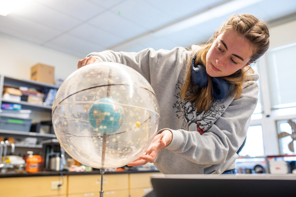 Putney student looking at a globe during a science class