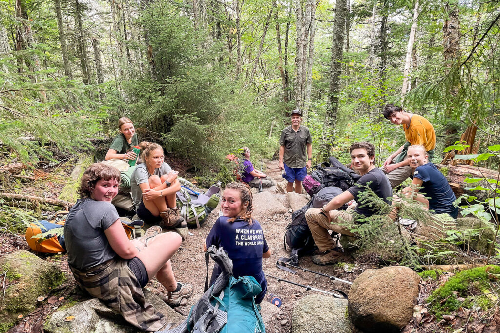 Students sitting on rocks during Putney's Long Fall camping trip. 